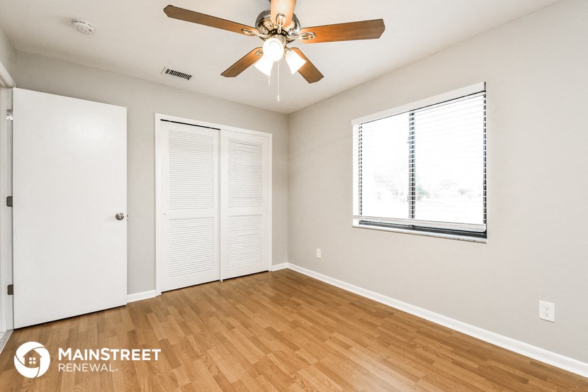 a living room with a ceiling fan and a window