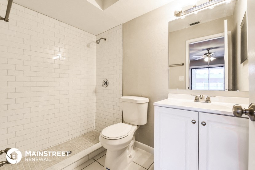 a bathroom with a toilet and a sink and a mirror