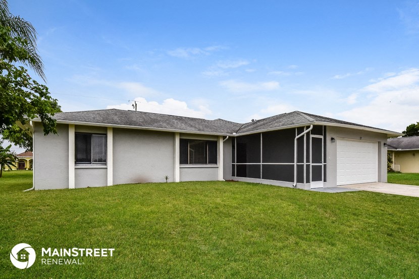 a white house with a lawn and a garage