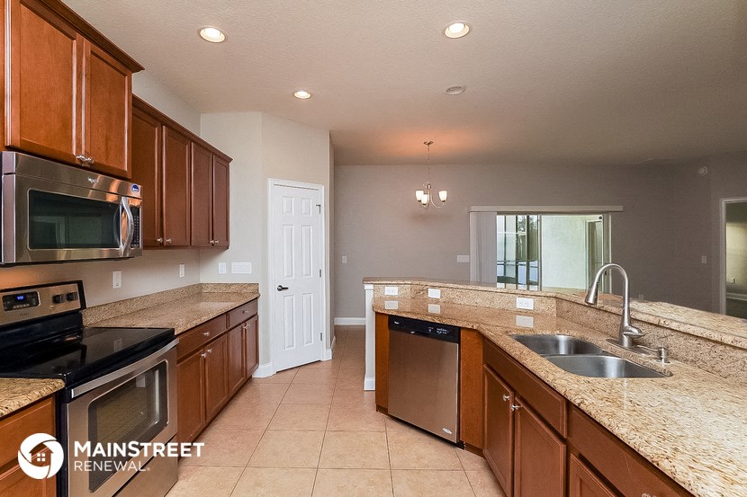 a kitchen with granite counter tops and wooden cabinets