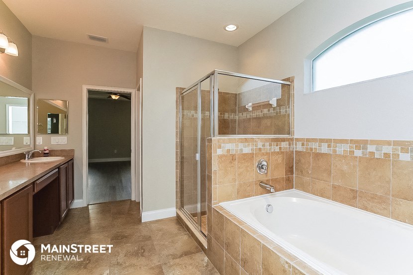 a bathroom with a tub and a shower and a sink