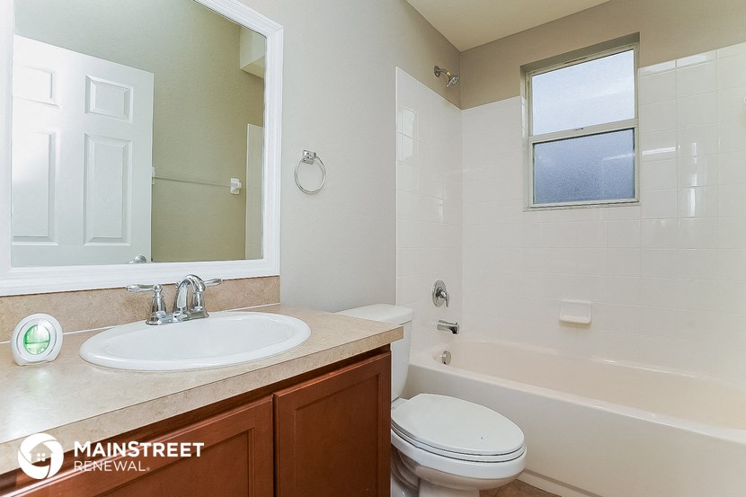 a bathroom with a sink toilet and a mirror
