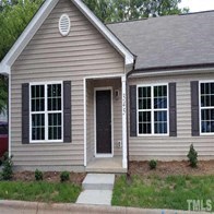 a brown house with black shutters and a front porch