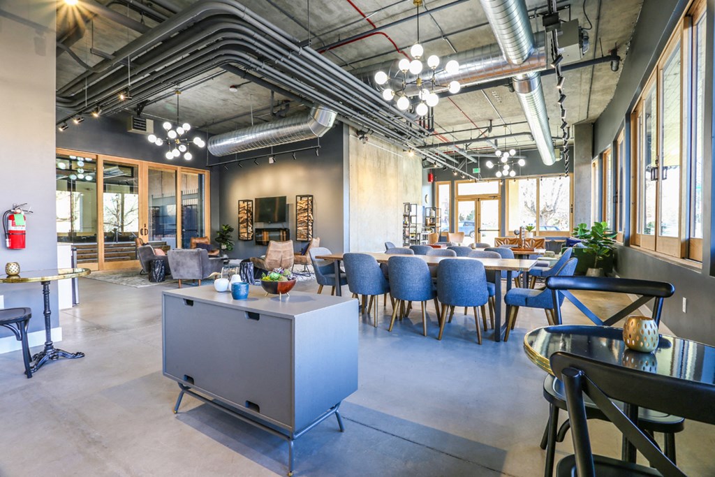 a living room with tables and chairs and a kitchen