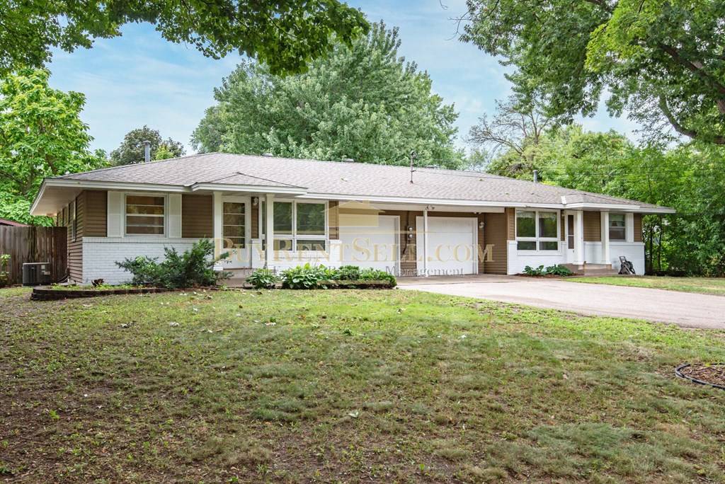 a small white house with a lawn and trees