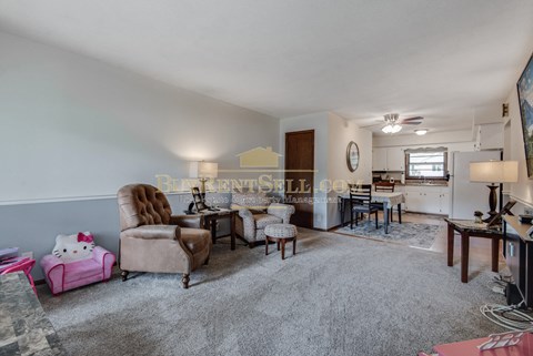 a living room with a couch and a chair and a kitchen