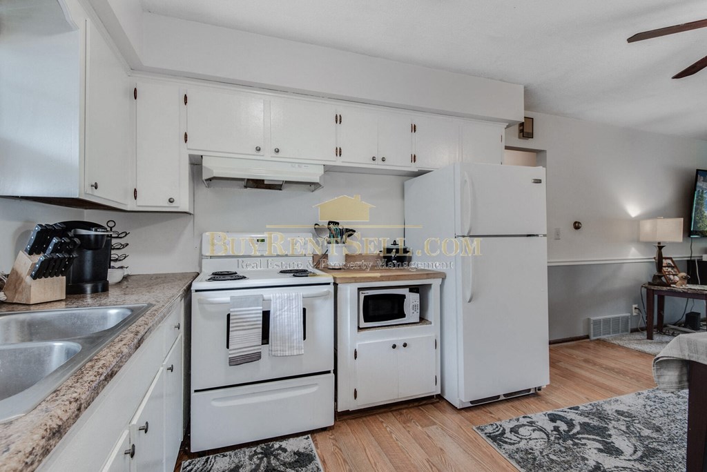 a white kitchen with white appliances and white cabinets