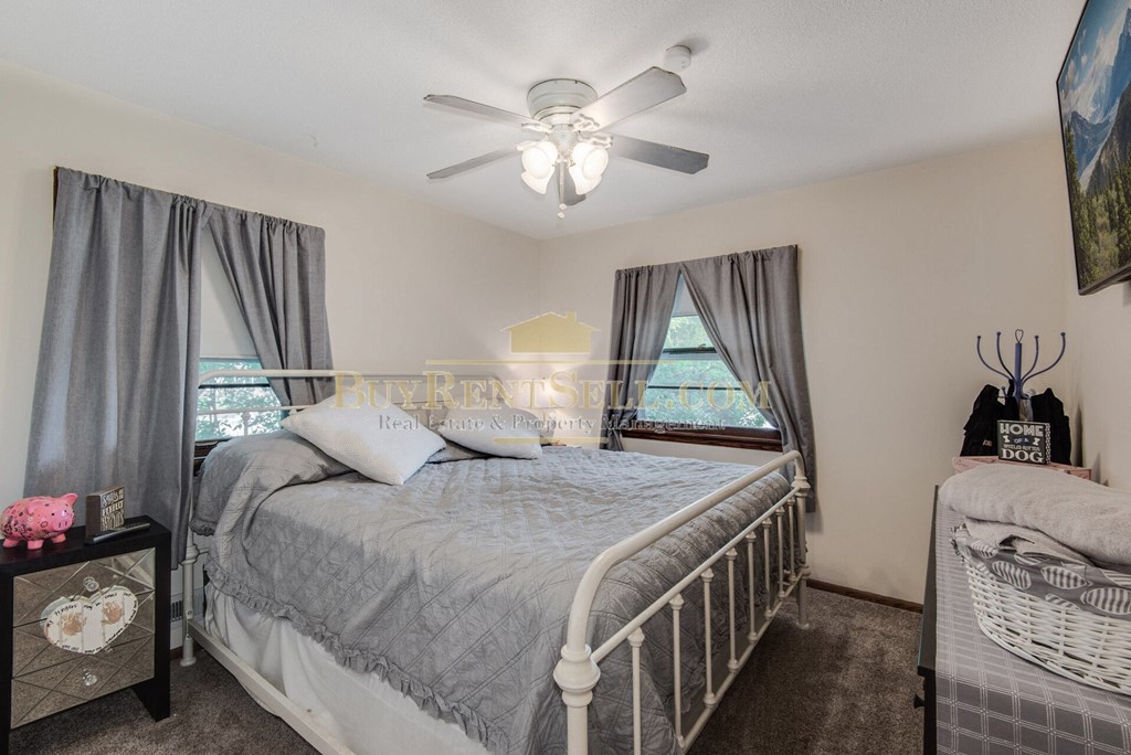 a bedroom with a bed and a ceiling fan