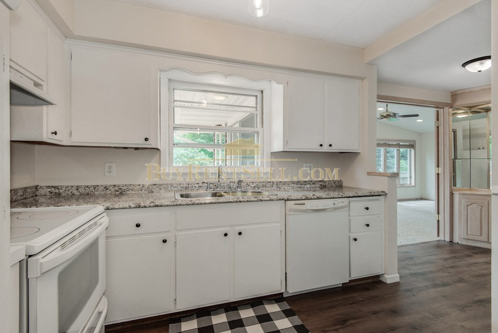 a kitchen with white cabinets and a granite counter top