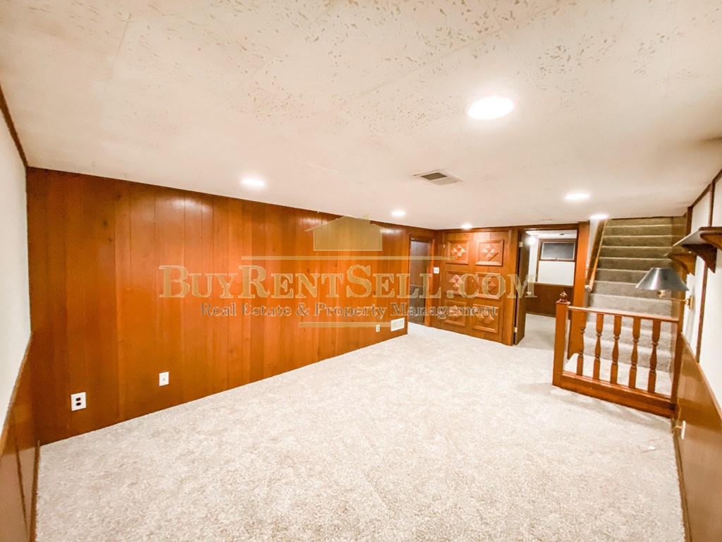 the upstairs living room and stairway of a house with white carpet and a staircase