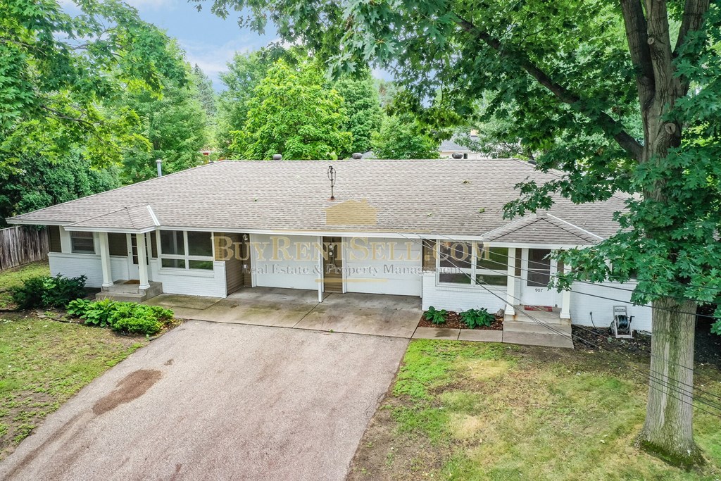 a white house with a driveway and trees