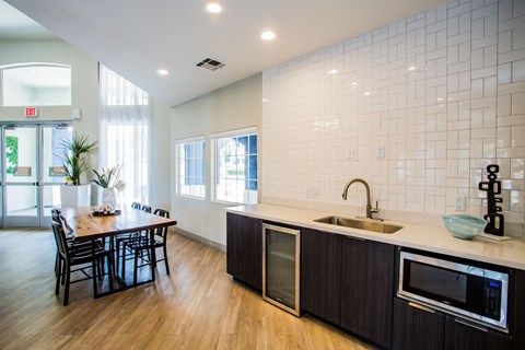 A kitchen with a table and chairs and a sink.