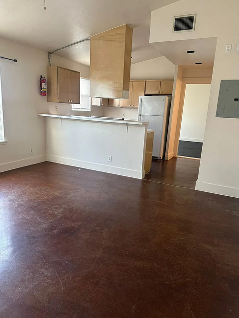 A kitchen with brown floors and white walls.