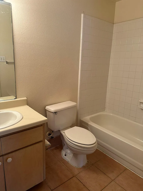 A white toilet sits next to a sink in a bathroom.