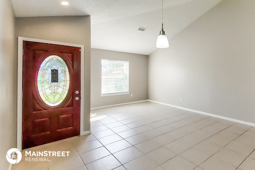 an empty living room with a door with a stained glass window