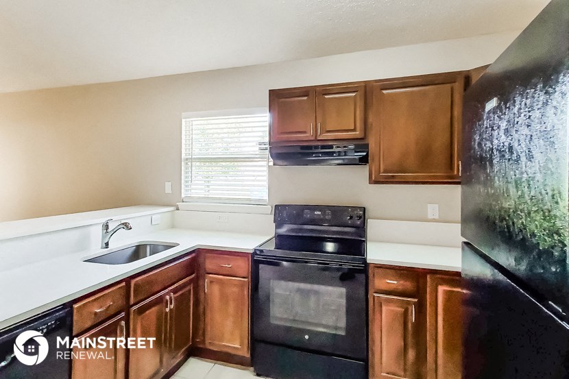 a kitchen with black appliances and wooden cabinets