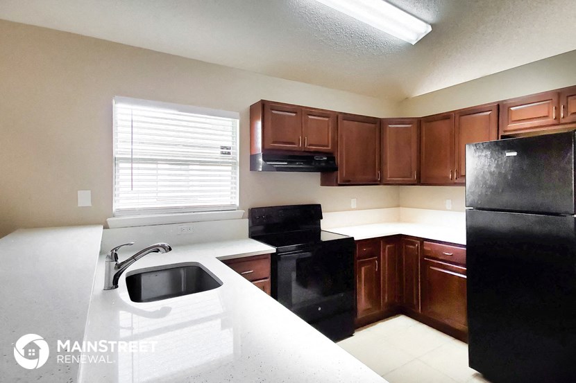 a kitchen with black appliances and white counter tops
