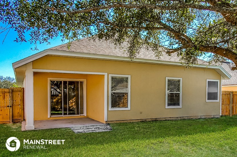 a small house with a yard and a tree