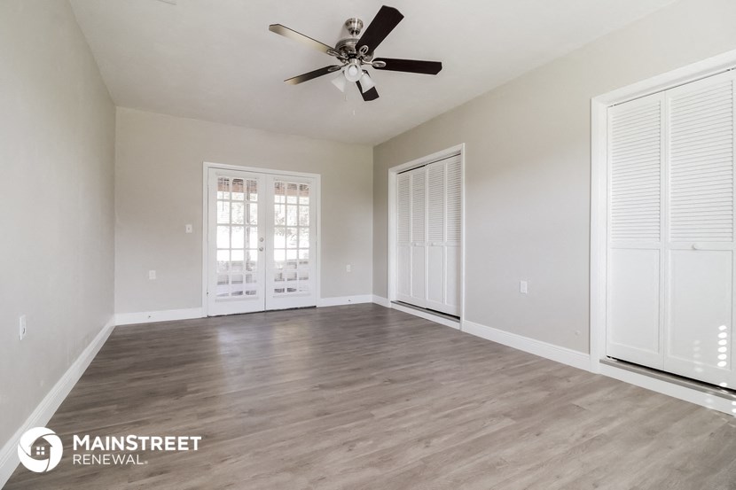 the living room of an empty house with a ceiling fan