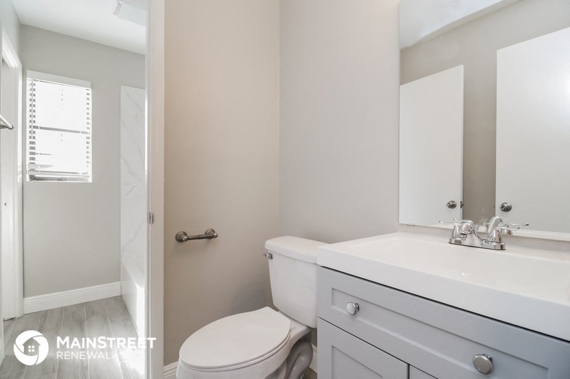 a bathroom with a toilet and a sink and a mirror