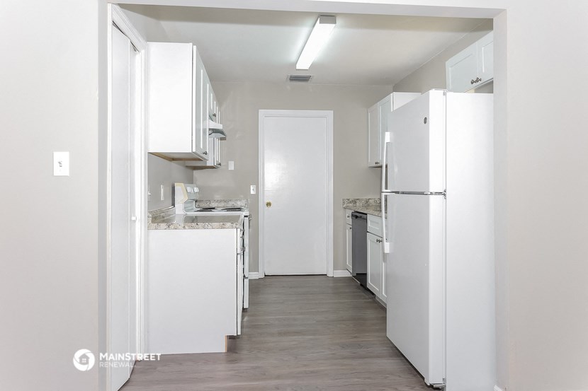 a white kitchen with white cabinets and white appliances and a white refrigerator