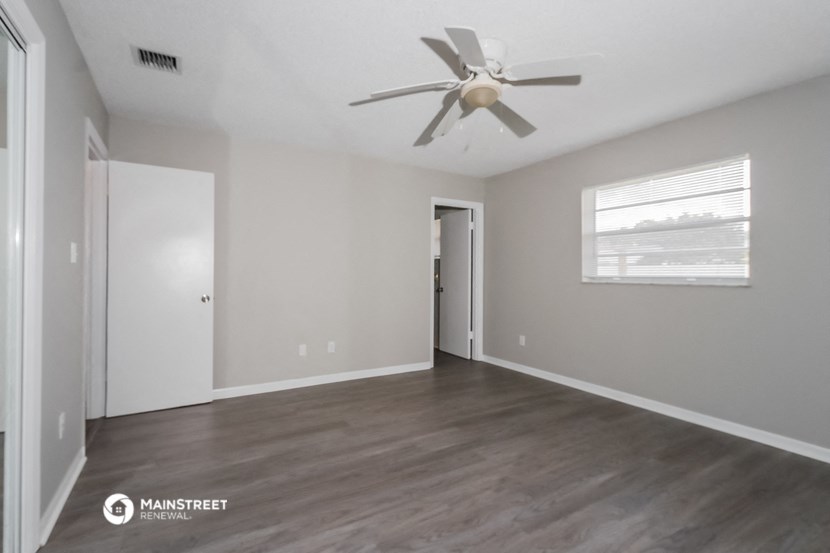 the living room of an empty house with a ceiling fan