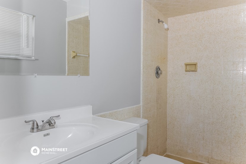 a bathroom with a sink and a shower and a toilet