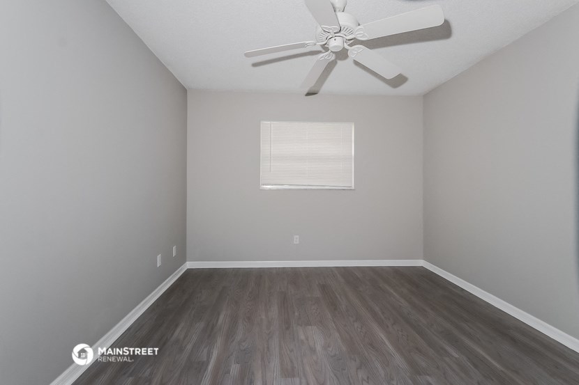 a room with wooden floors and a ceiling fan