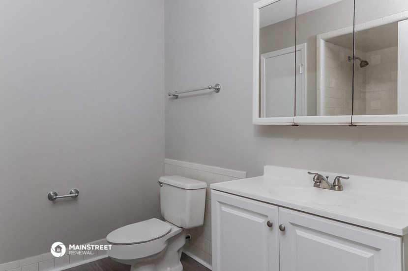 a white bathroom with a toilet and a sink