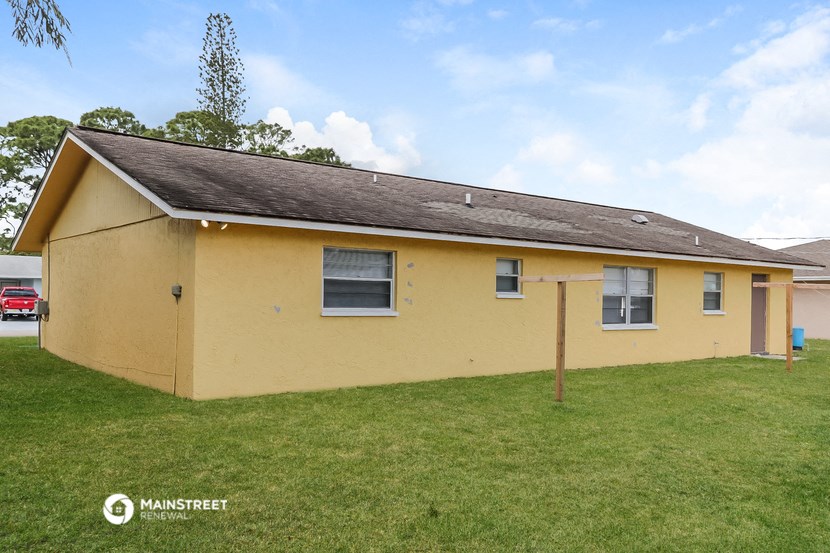 a small yellow house with a grassy yard