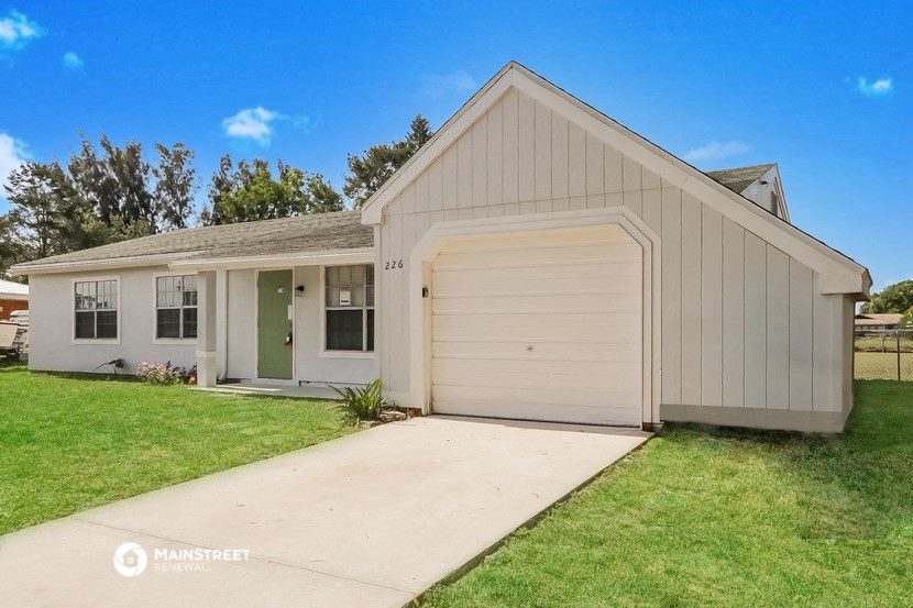 a white house with a white garage door and a driveway