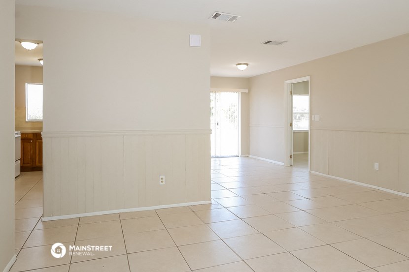 the living room and dining room of an empty house
