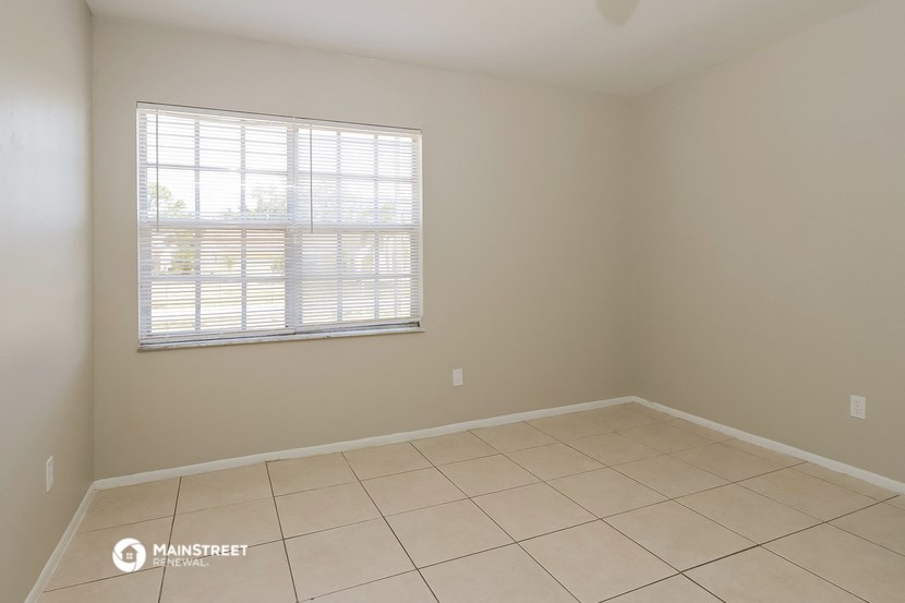 an empty room with a window and a tiled floor