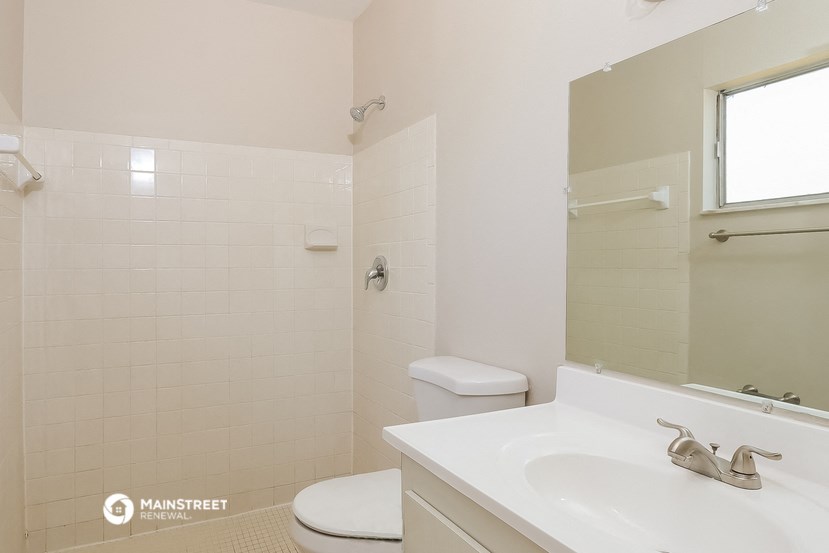 a bathroom with a sink toilet and shower and a mirror