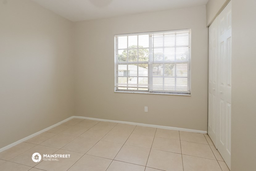 an empty room with a window and a tiled floor