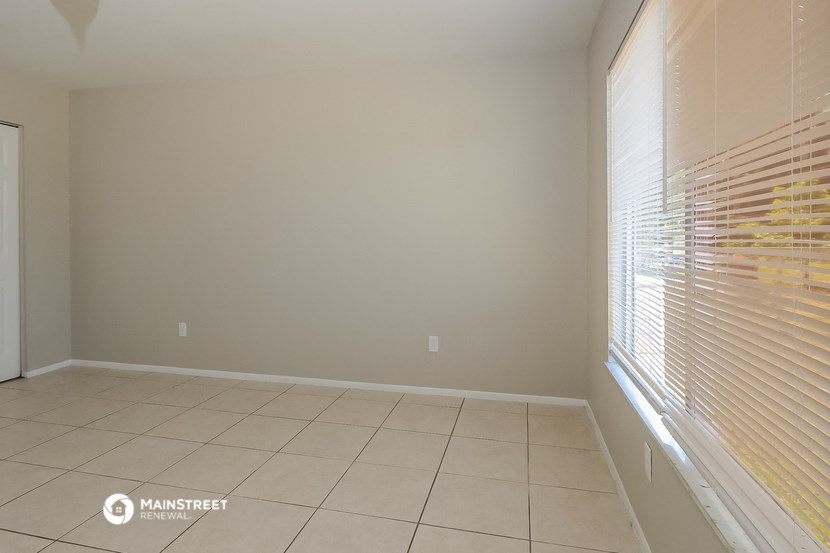 a living room with a large window and a tiled floor
