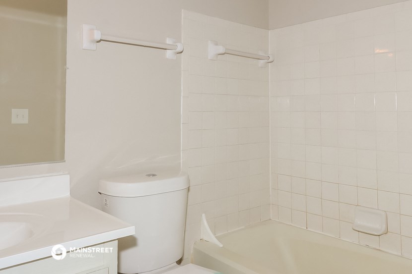 a bathroom with a toilet and a tub and a sink