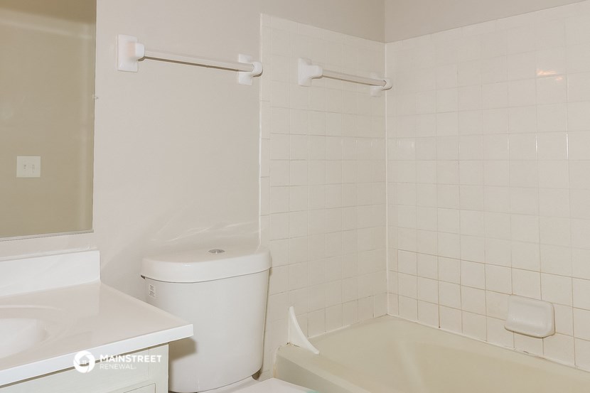 a bathroom with a toilet and a tub and a sink