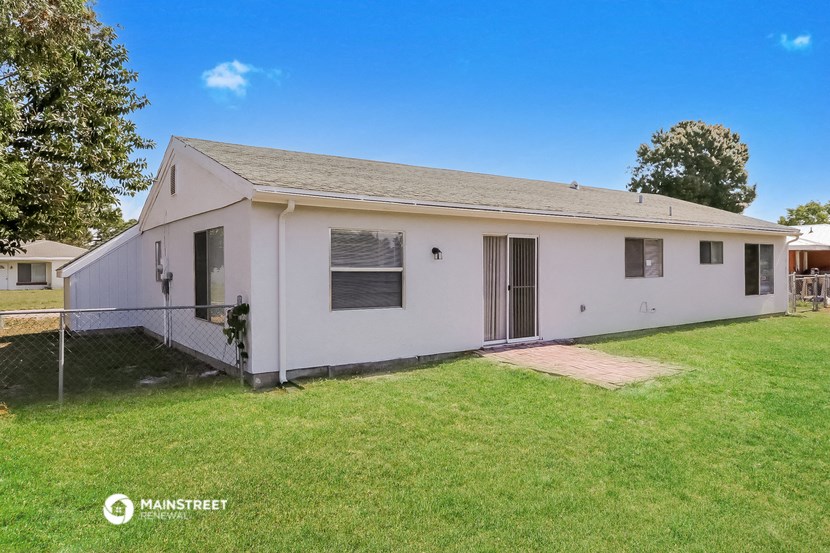 a small white house with a yard and a lawn