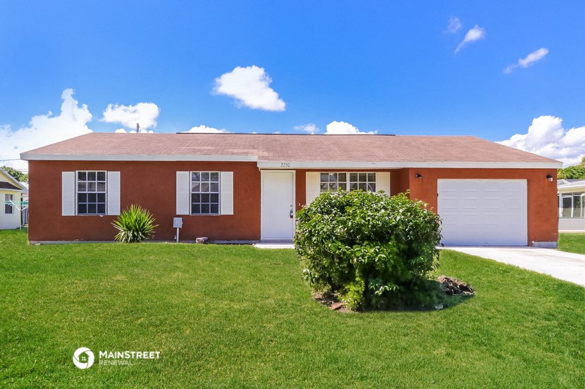 a red brick house with a lawn in front of it