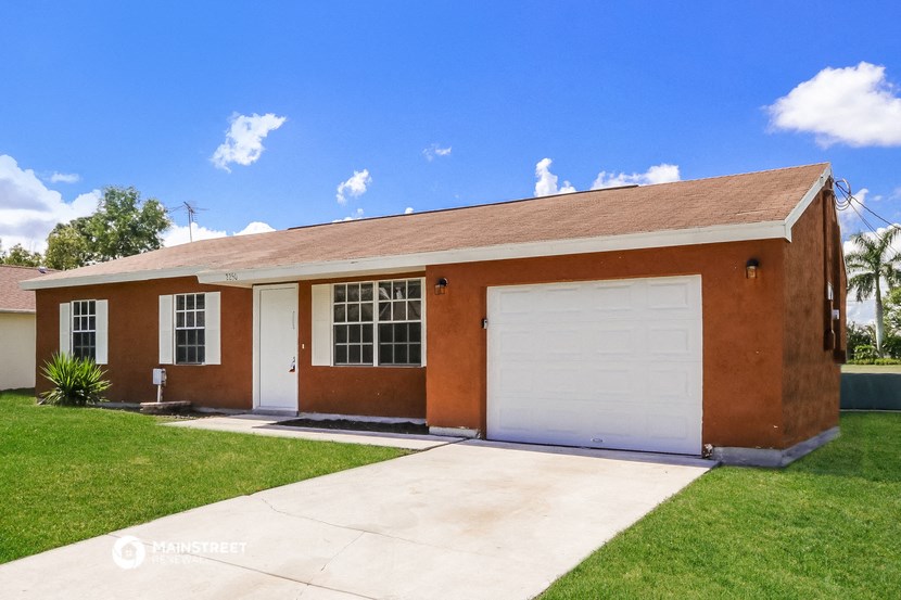 a small brick house with a white garage door