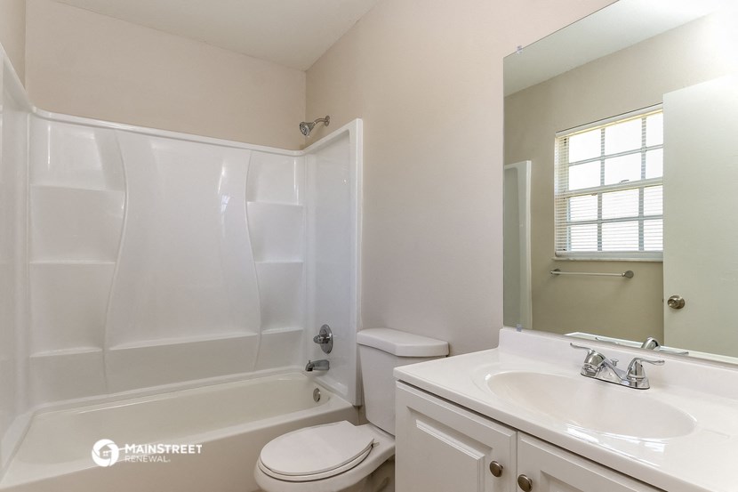 a bathroom with a sink toilet and tub and a mirror