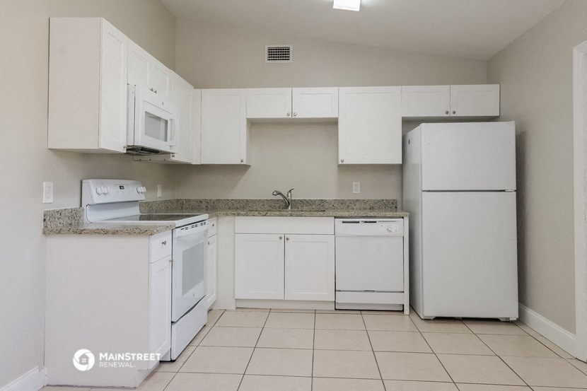 a kitchen with white appliances and white cabinets