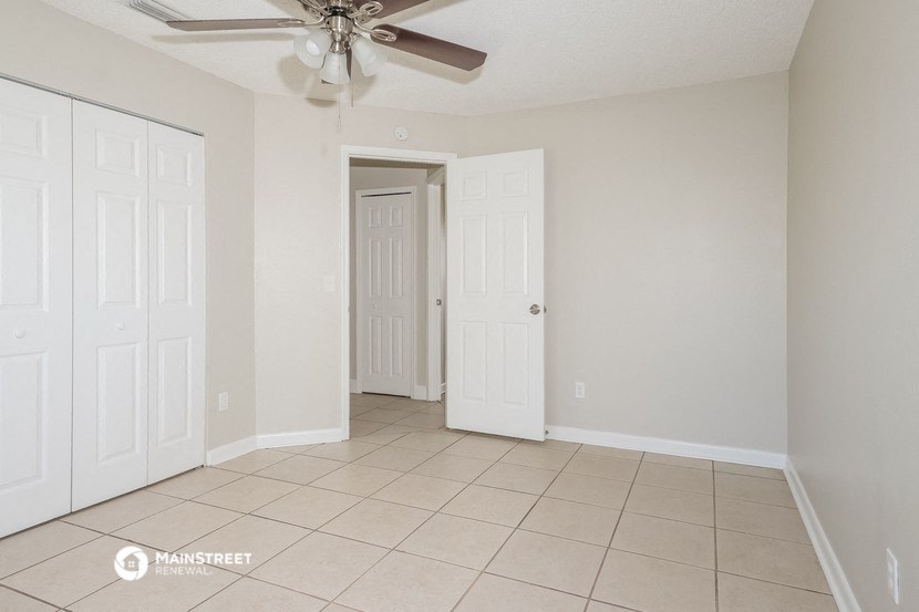 the living room of an empty house with a ceiling fan