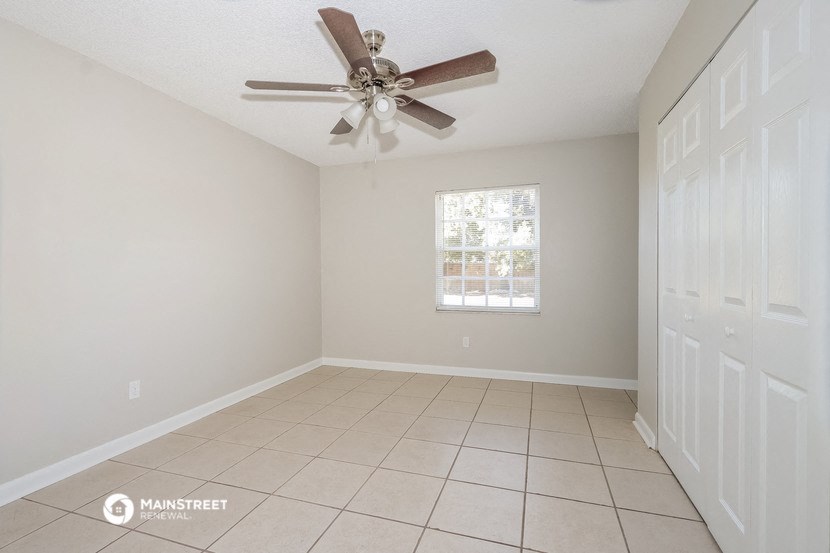 a empty living room with a ceiling fan