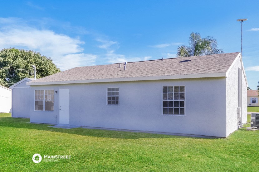 a white house with a grassy yard and a blue sky