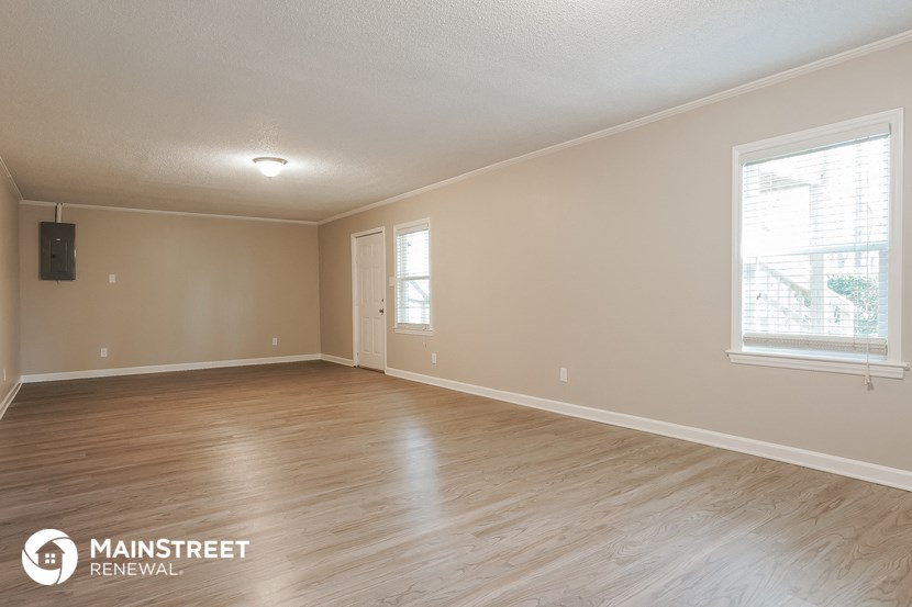 the living room of an empty house with wood flooring