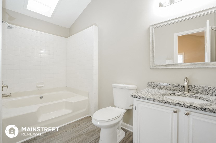 a white bathroom with a toilet and a tub and a sink
