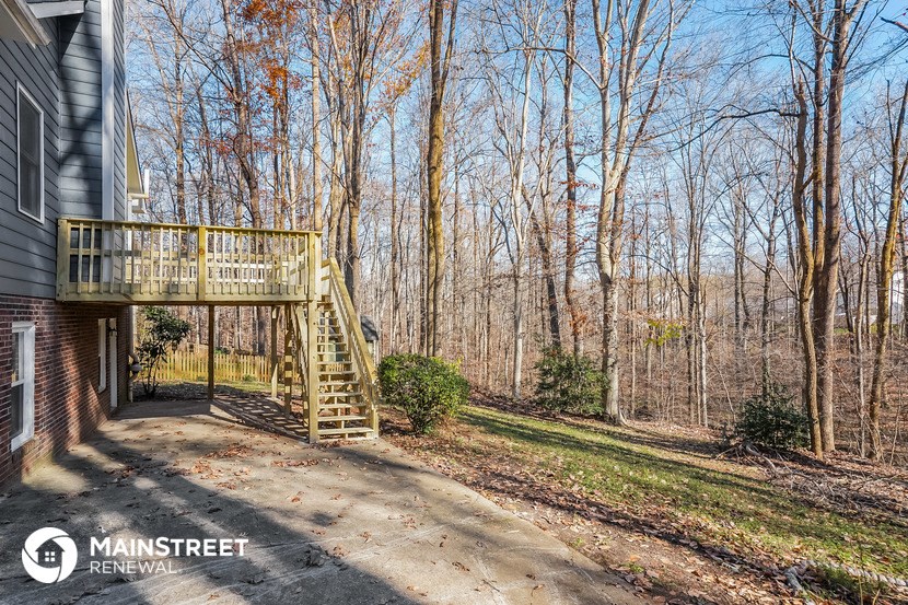 a porch with a deck on a house in the woods