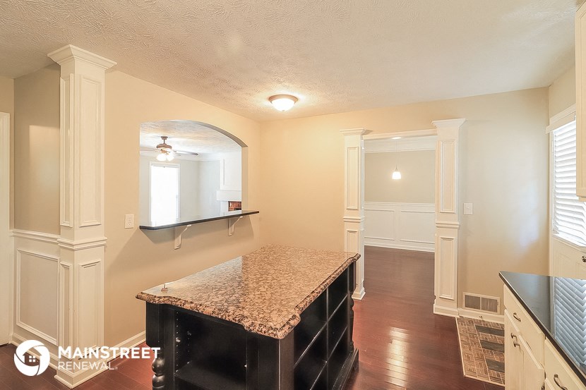 a kitchen with white cabinets and a granite counter top